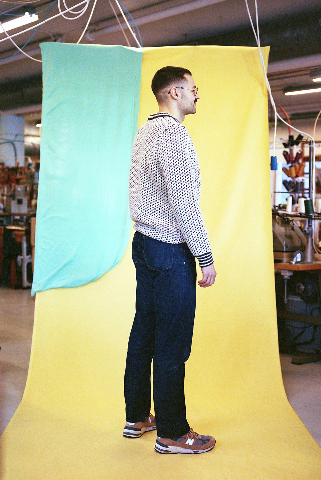Man standing in front of a colorful curtain with a room interior in the background