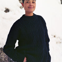 Person wearing a black sweater standing in a snowy landscape