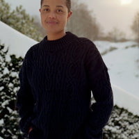 Person wearing a dark sweater standing in a snowy landscape