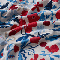 Close-up of floral fabric with red, blue, and white flowers on a white background