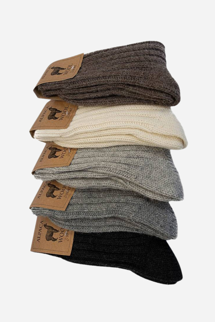 Stack of brown, beige, gray, and black socks with labels on a white background