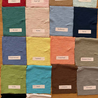 Collection of colorful fabric swatches arranged in a grid on a wooden surface.