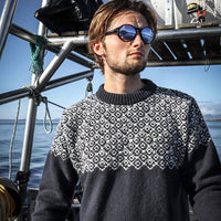 Devold Nansen Sweater in Ink/Off White on model on a boat.