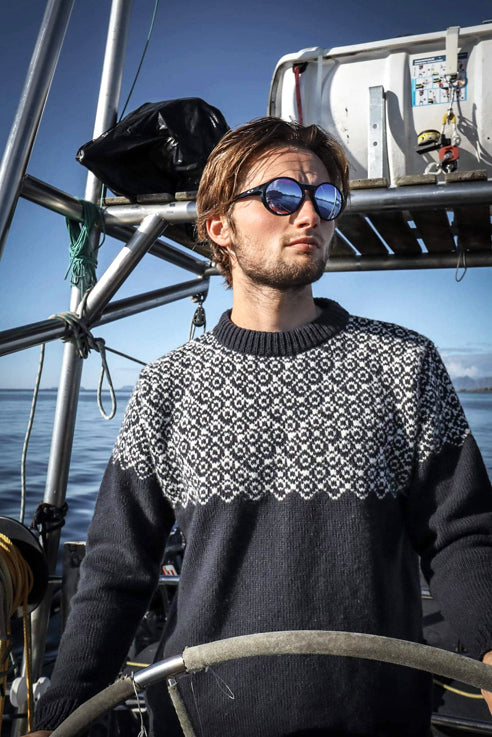 Devold Nansen Sweater in Ink/Off White on model on a boat.