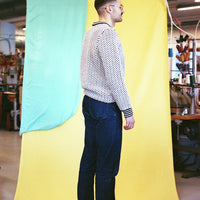 Man standing in front of a colorful curtain with a room interior in the background