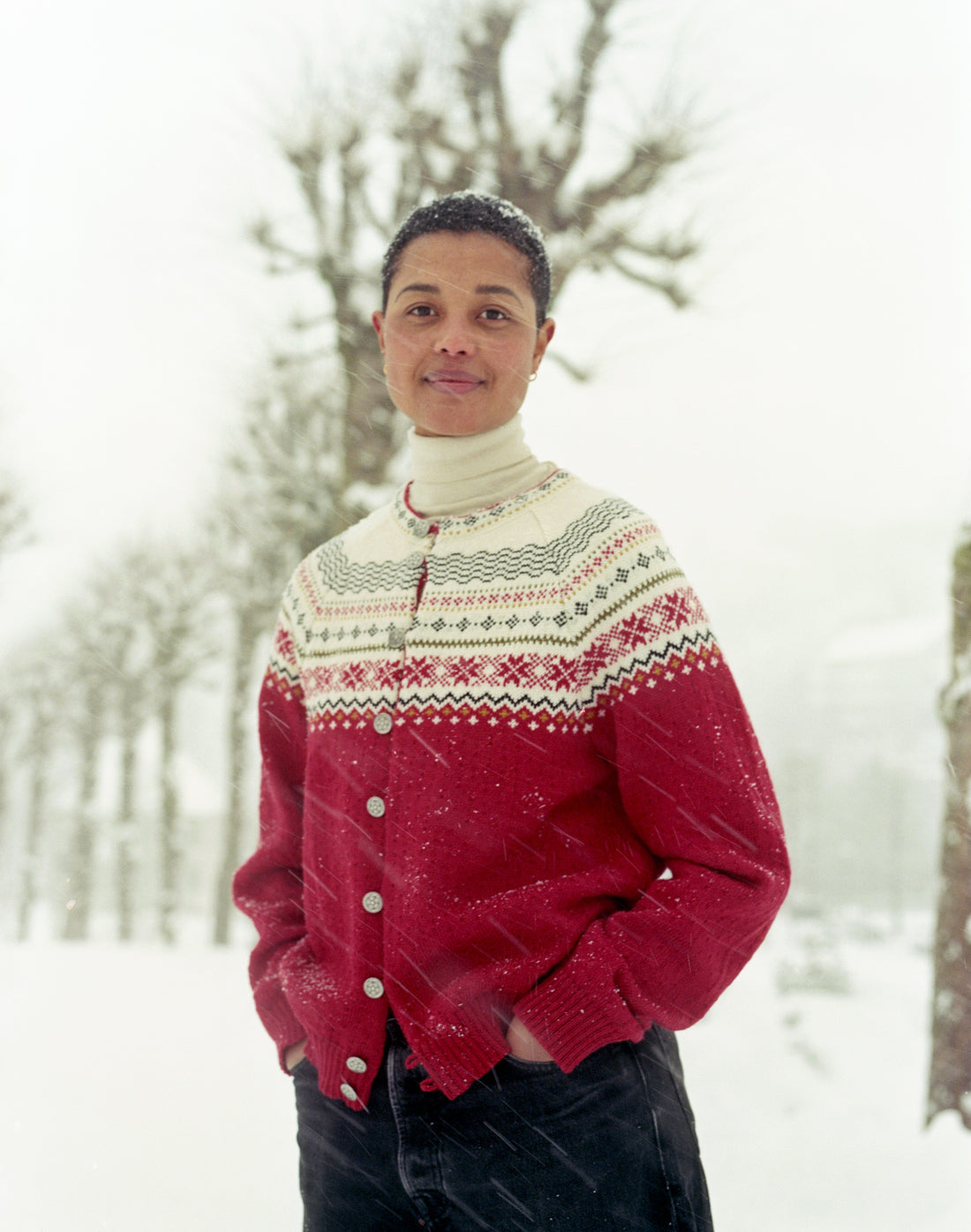 Person wearing a red and white patterned sweater in a snowy landscape