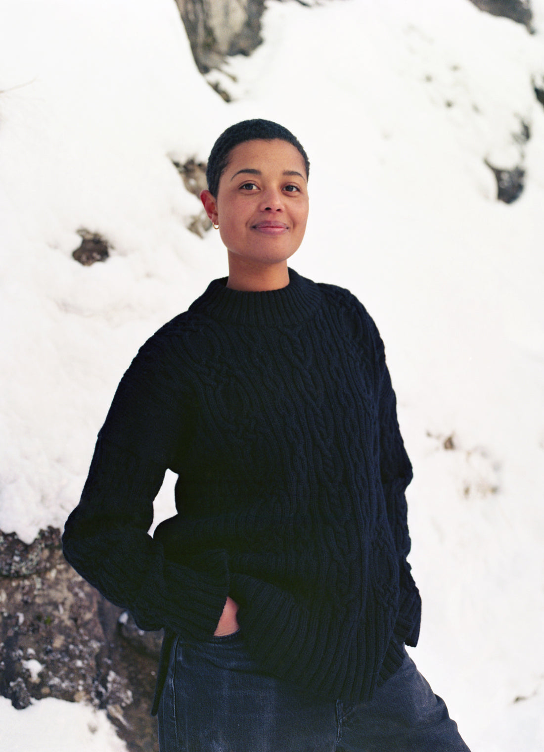 Person wearing a black sweater standing in a snowy landscape