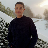 Person wearing a dark sweater standing in a snowy landscape