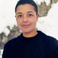 Person wearing a dark blue sweater with a snowy landscape in the background