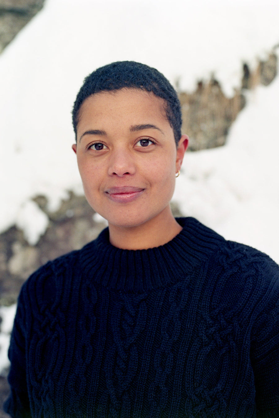 Person wearing a dark blue sweater with a snowy landscape in the background