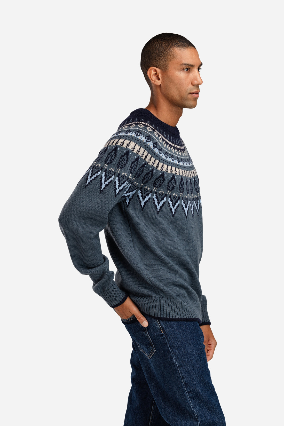 Man wearing a dark gray sweater with a patterned design on a white background