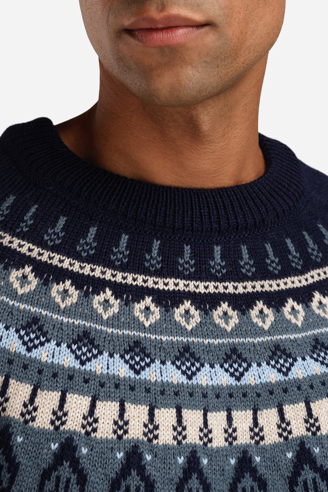 Navy blue sweater with white and light blue pattern worn by a person