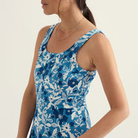 Woman wearing a blue floral dress against a white background