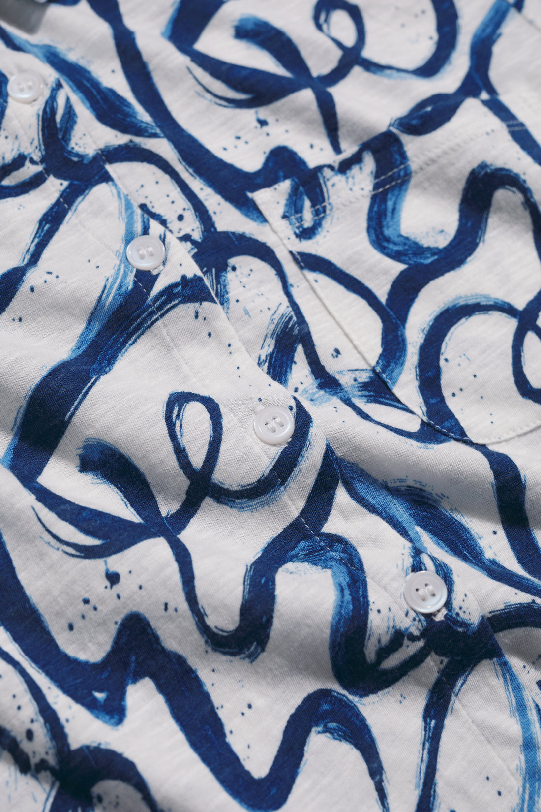 Close-up of a shirt with blue abstract pattern on white background