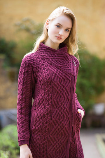 Woman wearing a purple knitted dress with a geometric pattern outdoors.